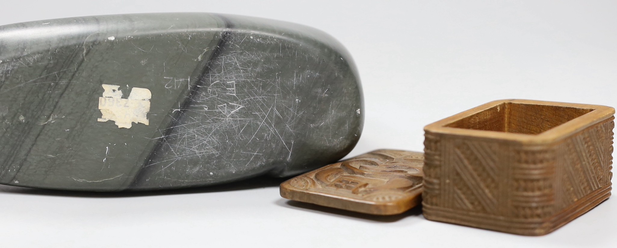 An Inuit stone figure of a seal and a Maori box and cover, carving 22cm long